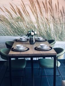 a wooden table with chairs and a vase of flowers at BLOC79/4 in Knokke-Heist +25 photos