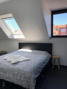 a bedroom with a bed and two windows at BLOC79/4 in Knokke-Heist