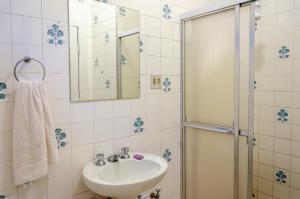 uma casa de banho com um lavatório e um chuveiro em Beer Hostel Suites Privativas e Compartilhadas em Ilhabela