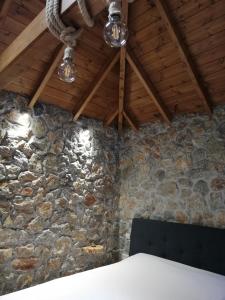 a room with a stone wall and a ceiling with lights at Olympus Country House in Kariá