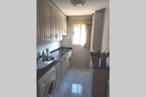 a kitchen with a sink and a washing machine at Apartamento La Parra in Arenas de San Pedro
