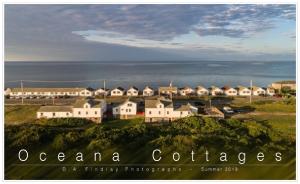 a group of houses on a hill next to the ocean at Oceana Cottages in North Truro