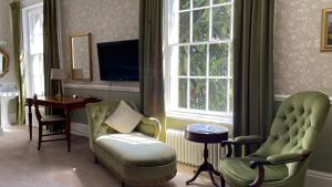 a living room with two chairs and a table at Ashdale Guesthouse in Matlock