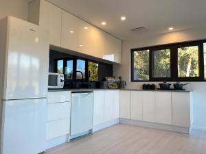 a kitchen with white cabinets and a white refrigerator at Altura Apartment Bright in Bright