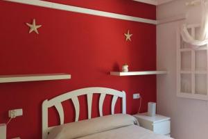 - une chambre dotée d'un mur rouge avec des étoiles dans l'établissement La casa de la Palmera, à Torrevieja