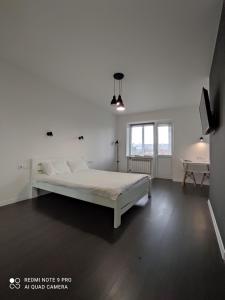 a white bedroom with a bed and a table at White Apartment in Poltava