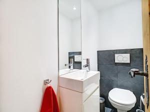 a bathroom with a white sink and a toilet at Square Poste 237 in Verbier