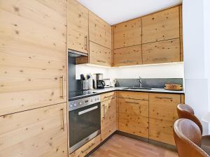 a kitchen with wooden cabinets and a stove at Square Poste 237 in Verbier
