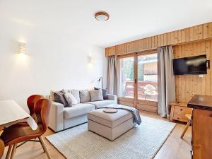 a living room with a white couch and a tv at Square Poste 237 in Verbier
