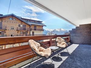 two chairs on a balcony with a view of mountains at Square Poste 237 in Verbier