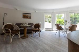 a living room with a couch and a table and chairs at Muschel 2 in Ahrenshoop +20 photos
