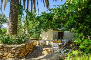 a patio with a table and chairs under a tree at Beautiful country house near Ronda in Arriate