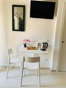 comedor con mesa, sillas y TV en La Stanza Dei Desideri, en Peschici