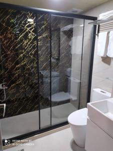 uma casa de banho com uma cabina de duche em vidro e um WC. em Sofu Hotel em Taipei