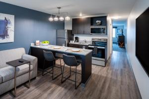 a kitchen and living room with a bar and a couch at stayAPT Suites Alexandria-Fort Belvoir in Alexandria
