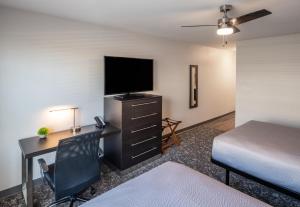 a bedroom with a desk with a bed and a television at stayAPT Suites Alexandria-Fort Belvoir in Alexandria