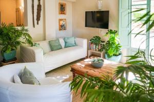 a living room with white furniture and potted plants at Beautiful country house near Ronda in Arriate