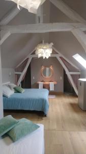 a attic room with two beds and a mirror at Les Dames-Jeannes in Chavot-Courcourt