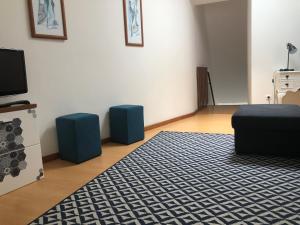 a living room with a rug and blue stools at Central House in Ribeira Grande