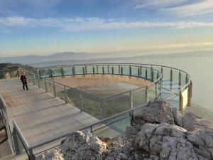 a person standing on a walkway over the water at Apartment Kastel in Podgora