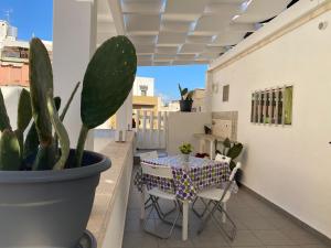 a table and chairs on a balcony with a cactus at La Corte 22 in Marsala