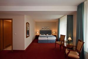 a hotel room with a bed and a table and chairs at Villa Knobelsdorff in Pasewalk