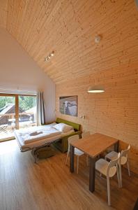 ein Schlafzimmer mit einem Bett und einem Tisch in einem Zimmer in der Unterkunft Apartmány Chata Večernice in Dolní Morava