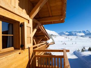 a log cabin with a view of the snow at Madame Vacances Chalet Marmotte in LʼHuez