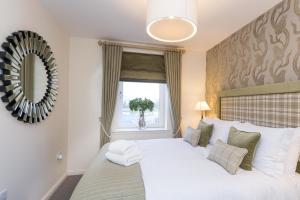 a bedroom with a large white bed with a window at Town and Country Charleston Apartments in Aberdeen