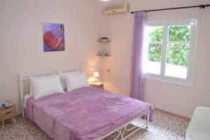 a bedroom with a purple bed and a window at Dolce Casa: Athenian Residence with private Garden in Athens