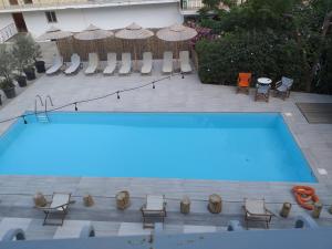 an empty swimming pool with chairs and umbrellas at Ψιλή Άμμος in Tolo