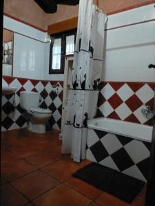 een badkamer met een toilet en een douchegordijn bij Casa Rural Laura in Miranda del Castañar
