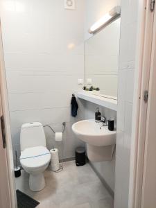 ein weißes Badezimmer mit Toilette und Waschbecken in der Unterkunft Apartament Willa Dorota 1 by Edyta in Świnoujście + 6 Fotos