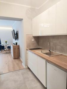 eine Küche mit weißen Schränken, einer Spüle und einem Tisch in der Unterkunft Apartament Willa Dorota 1 by Edyta in Świnoujście