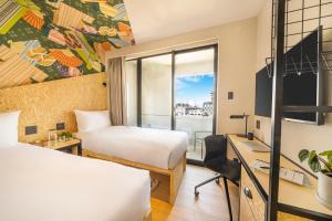 a hotel room with two beds and a desk and a window at lyf Tenjin Fukuoka in Fukuoka