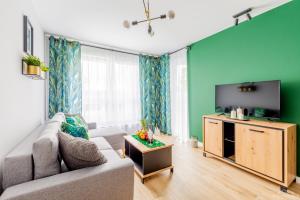 a living room with a couch and a flat screen tv at Apartament BAILANDO in Kołobrzeg