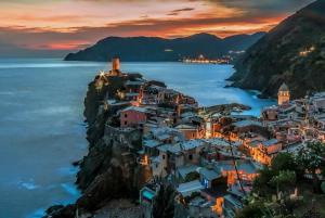 uma aldeia num penhasco no oceano ao anoitecer em Santa Marta Rooms - Via Del Santo 25 em Vernazza