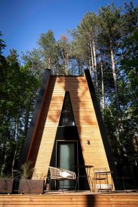 une petite maison avec un triangle coupé. dans l'établissement Bain de forêt - Lodges Cosy & Spa, à Neufchâtel-Hardelot