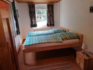 Posto letto in una piccola camera con finestra di Gemütliche Ferienwohnung 2 Personen im Wendland / Elbe a Trebel