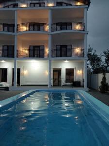 a building with a swimming pool in front of a house at Villa Bonapart in Zatoka