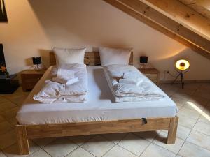 a bed with white sheets and pillows in a room at Ferienwohnung Hubertus in Holzkirchen