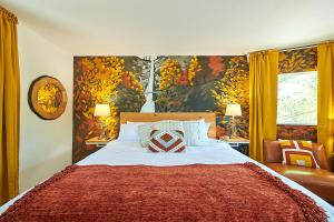 a bedroom with a large bed with a red blanket at Kenton Hotel in Portland