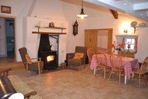 sala de estar con chimenea, mesa y sillas en Cecil's Cottage, Ballynary, Buncrana by Wild Atlantic Wanderer en Buncrana