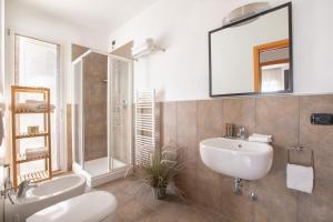 La salle de bains est pourvue d'un lavabo, de toilettes et d'un miroir. dans l'établissement Residenza D-Place Ponchielli, à Riccione