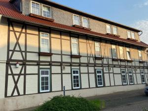 a brown and white building with a red roof at Harzhotel Warnstedter Krug in Thale