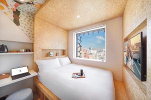 a small bedroom with a white bed and a window at lyf Tenjin Fukuoka in Fukuoka