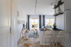 eine Küche und ein Wohnzimmer mit einem Tisch und Stühlen in der Unterkunft OleHolidays Romana Playa 334 vistas al mar in Marbella