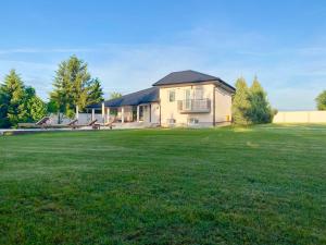 a house with a large grass field in front of it at LA CASITA Serbia in Surčin