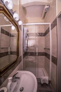 a bathroom with a sink and a shower with a mirror at WELL COME - Palazzo Reale in Naples