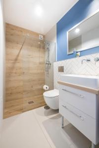 a bathroom with a toilet and a sink and a shower at Apartamenty Rzemieślnicza 5 in Władysławowo +9 photos
